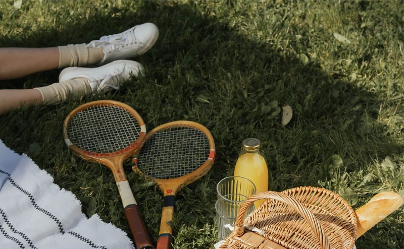 Tennis rackets and a picnic on the grass